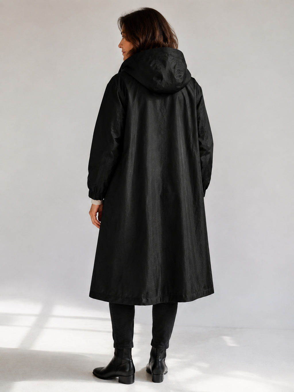 Theodora Hooded Longline Trench Coat in Black on a 40+ model, back view