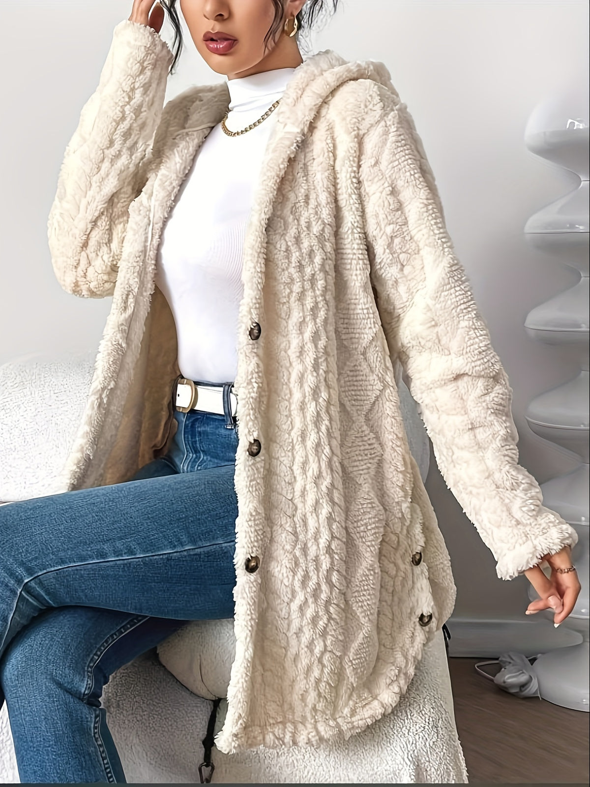 Cora plush hooded longline cardigan in cream, worn seated with jeans