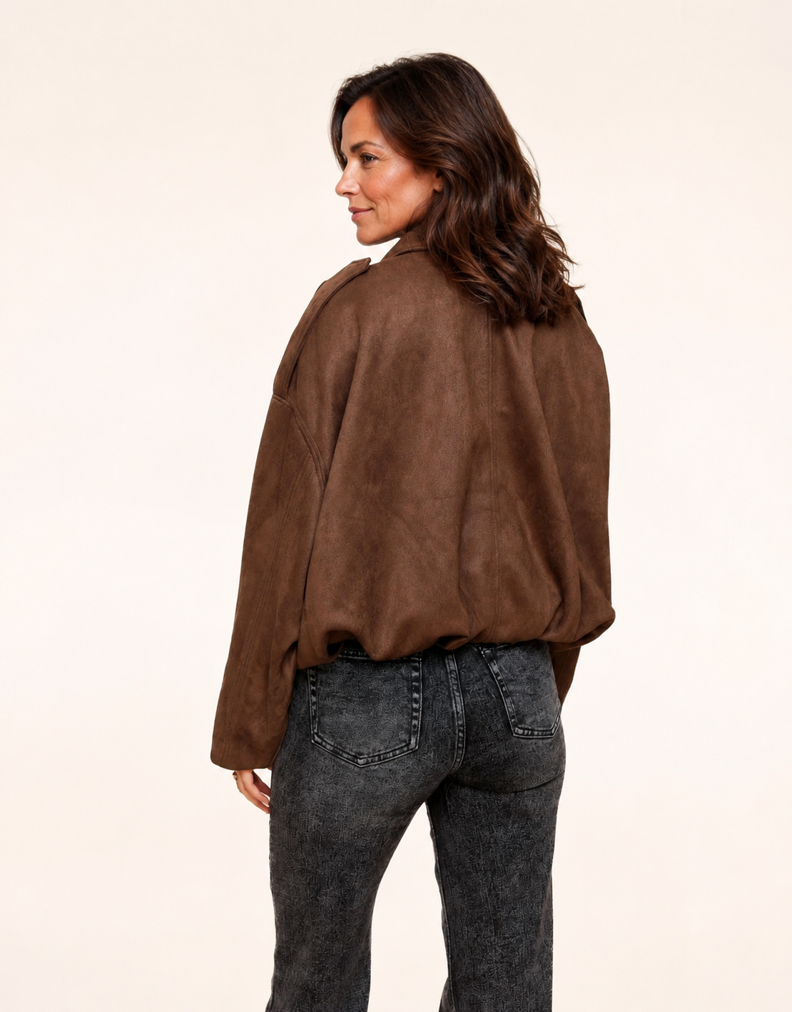 Fit mature woman wearing dark brown faux-suede oversized bomber jacket, back view