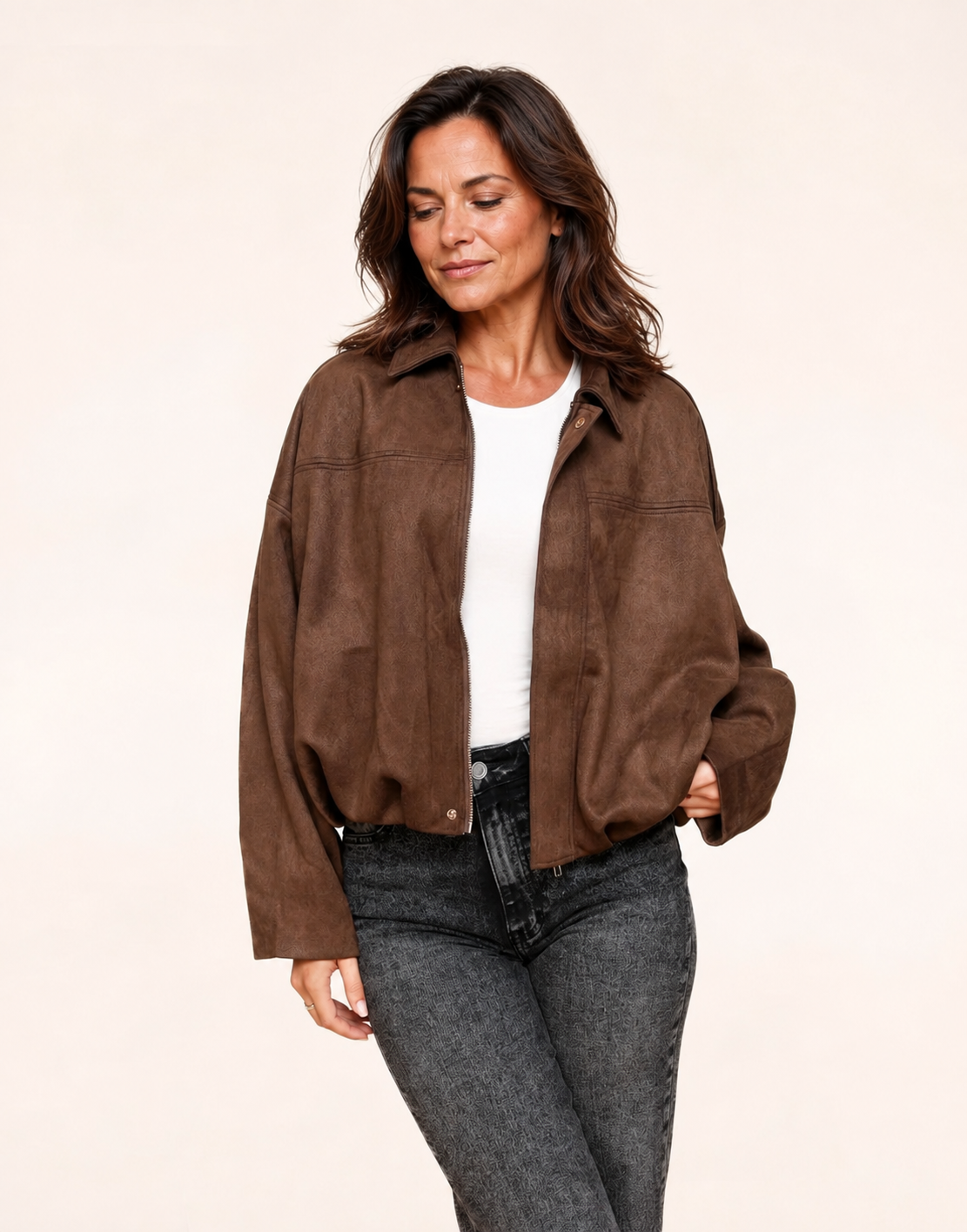 Fit mature woman wearing dark brown faux-suede oversized bomber jacket, three-quarter view