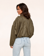 Fit mature woman wearing khaki faux-suede oversized bomber jacket, back view