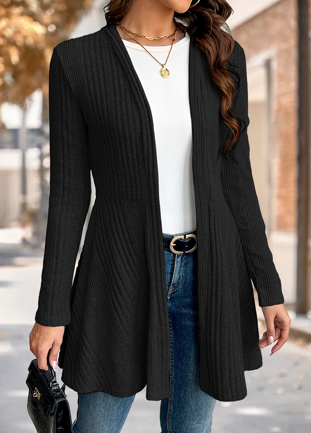 Woman wearing the Nora comfort knit open front cardigan in black over a white tee and blue jeans, front view