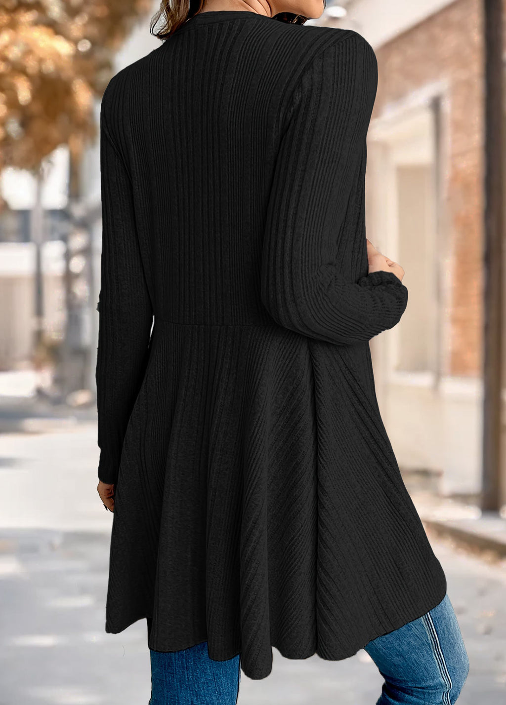 Back view of the Nora comfort knit open front cardigan in black, showing the waist seam and flared tunic length