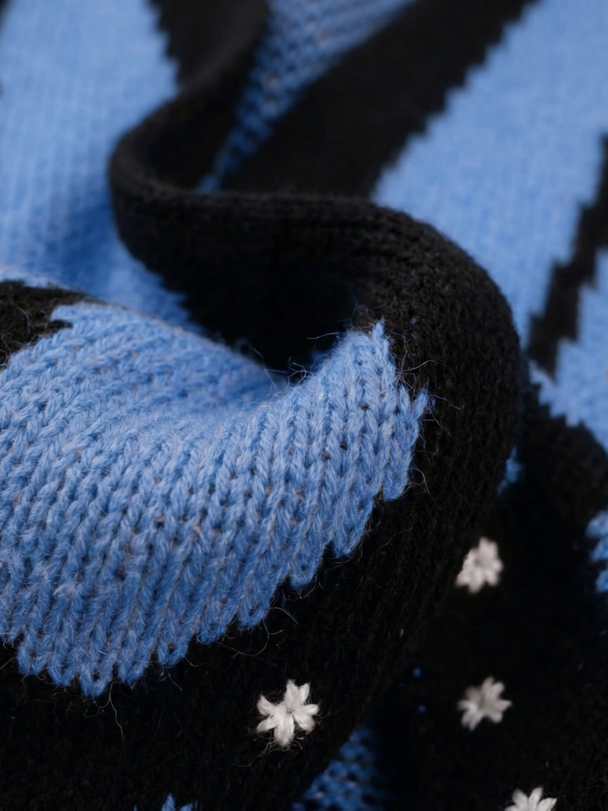 Close-up of the Vivienne knit showing the blue and black wing pattern and scalloped edge